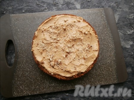 Теперь нужно сварить сироп, для этого в небольшом сотейнике нужно соединить воду с сахаром, поставить на огонь, довести до кипения, а затем проварить 2-3 минуты на небольшом огне. Снять сироп с огня, влить лимонный сок и коньяк, перемешать. Сироп остудить и пропитать им все части бисквита. Пропитанные коржи промазать кремом и посыпать измельчёнными орехами.