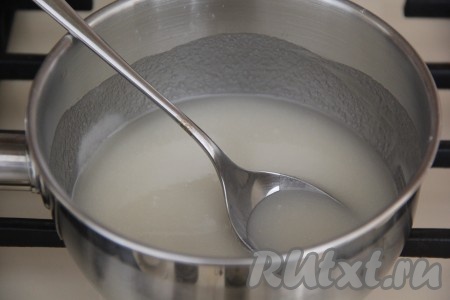 Творожные куличи, достав из духовки, полностью остудить, а затем можно приступать к приготовлению глазури. Для этого в сотейник нужно всыпать сахар и влить 30 мл воды. В отдельной посуде желатин залить 30 мл холодной воды и оставить набухать минут на 10-15. Сотейник с сахаром поставить на огонь и довести до кипения, затем варить сахарный сироп пару минут, помешивая (до полного растворения сахара). 