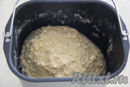 Выставить режим хлебопечки "Замес теста" на 1 час 20 минут. Если замешивать тесто руками, нужно соединить в глубокой миске подошедшую опару, сахар, творог, масло, яйца и яичные желтки. Перемешать и добавить муку с разрыхлителем. Замесить мягкое тесто. Даже если тесто будет немного липнуть к рукам, не добавляйте муку! Оставить тесто в миске на 1,5 часа.