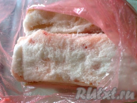 Если кусок сала широкий, то его надо нарезать на куски шириной 7-9 см. Далее куски сала надо обсыпать сахаром со всех сторон и выложить в пакет, который не пропускает жидкость (или в контейнер с крышкой). Сахар  вытянет всю жидкость из сала, жидкость останется в пакете, а сало  станет более плотным.