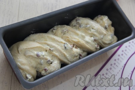 Выложить косу в форму для выпечки, хорошо смазанную маслом. Оставить пирог с творогом и изюмом для расстойки на 30 минут.