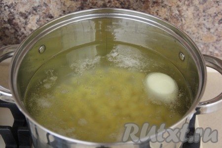 В кастрюлю влить 2,5 литра воды и довести на сильном огне до кипения. В кипящую воду опустить целую очищенную луковицу и нарезанную картошку, варить с момента закипания на небольшом огне 5 минут.