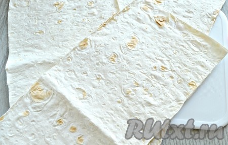 Тонкий лаваш разрезаем на прямоугольные полоски. Я нарезала на полоски размером 11 см на 30 см. Из двух лавашей у меня вышло 8 полосок. Вы ориентируйтесь на размер своего лаваша (у каждого производителя он может отличаться по размеру).
