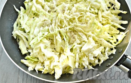 В сковороде разогреваем, примерно, 3 столовые ложки растительного масла, выкладываем сначала нарезанный лук. Обжариваем пару минут на среднем огне, потом добавляем нашинкованную капусту, солим по вкусу, перчим, перемешиваем.
