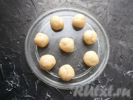 Тесто разделить на 8 частей, каждую часть скатать в шарик. Шарики разместить на стеклянной тарелке от микроволновки на достаточном расстоянии друг от друга.