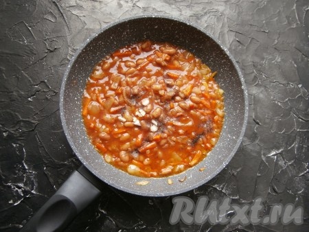 Перемешать фасоль с луком и морковью, протушить несколько минут, всыпать немного чёрного молотого перца, соль, сахар, добавить измельчённый чеснок.