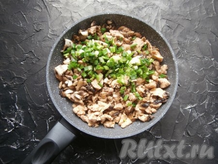 Перемешать грибы с курицей, обжаривать вместе 5-7 минут, не забывая периодически помешивать, после чего добавить измельчённый зелёный лук.