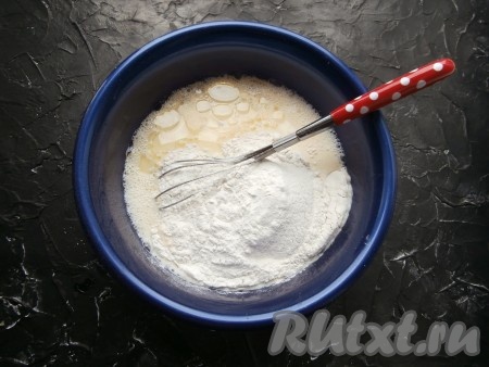 Получившуюся смесь хорошо перемешать венчиком, тщательно смешивая ингредиенты, затем влить растительное масло и всыпать муку.