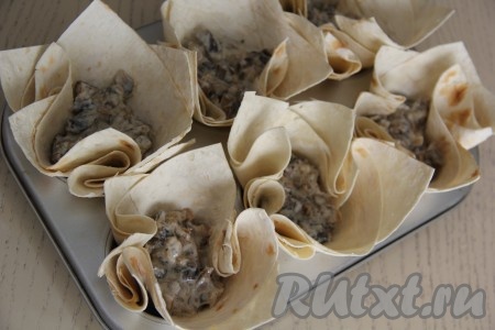 В корзиночки из лаваша равномерно разложить грибной жульен, сверху выложить натёртый сыр.