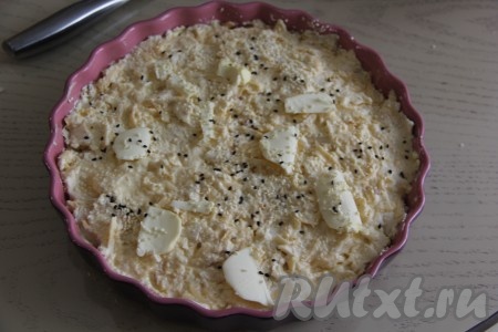 Выложить массу в форму (я выложила в форму диаметром 26 см), смазанную сливочным маслом. Слегка разровнять. Оставшееся сливочное масло нарезать на тонкие кусочки и равномерно разложить сверху пирога. По желанию, присыпать пирог кунжутом.