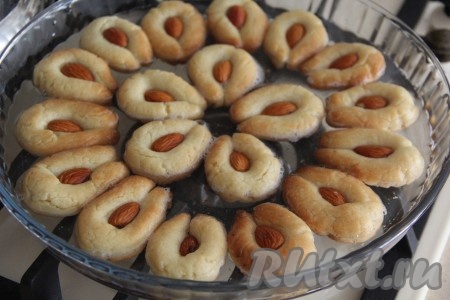 Переложить печенье в форму и аккуратно полить его горячим сиропом. Печенюшки должны быть в сиропе на половину. Оставить печенье с миндалём в сиропе на ночь. 