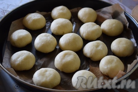 Форму диаметром 42 см застилаем пергаментом, смазанным 1 чайной ложкой растительного масла, и выкладываем на него булочки швом вниз на небольшом расстоянии друг от друга. Накрываем форму с булочками полотенцем и оставляем в тепле на 30-40 минут, чтобы булочки подошли.