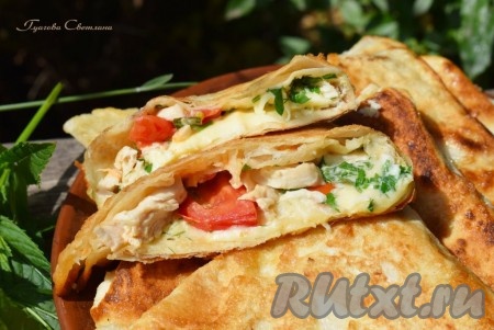 В разрезе лаваш выглядит очень аппетитно: сочная курица и помидоры, расплавленный сыр и ароматная зелень. Корочка у лаваша получается слегка хрустящей и румяной.

