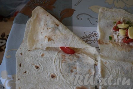 Сворачиваем каждую полоску лаваша треугольником, начиная со стороны с начинкой.