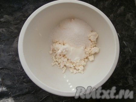 К творогу добавить 100 граммов сахара, ванильный сахар и 2-3 столовые ложки сметаны от общего количества.