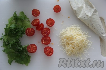 Пока пиццы выпекаются, нарезать помидоры черри на половинки, листья салата порвать на кусочки. Оставшийся соус выложить в кулинарный мешок.