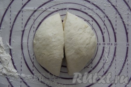 Готовое тесто обмять и разделить на две части (у нас получатся 2 пиццы). Если тесто будет липнуть, то припылите его мукой.