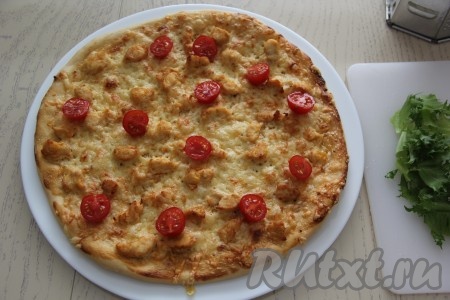 На горячую пиццу выложить дольки помидоров.