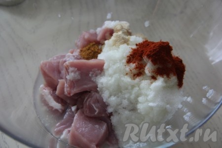 К кусочкам свинины добавить лук, соль и специи.