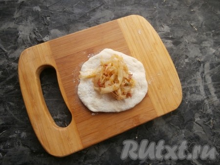 Разделить тесто на кусочки весом по 40-45 грамм (получится 14-15 кусочков), сформировать каждый кусочек в лепёшку. В середину каждой лепёшки поместить по 1 столовой ложке начинки из капусты.