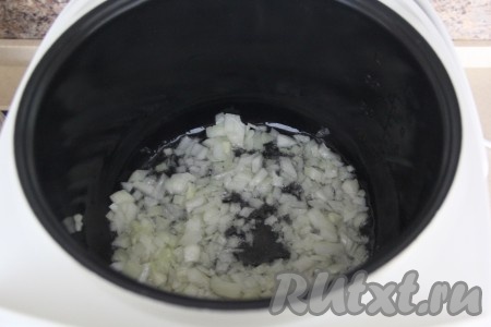 В чашу мультиварки влить растительное масло, выставить режим "Жарка", выложить лук и обжарить, помешивая и не закрывая крышку, в течение 3-5 минут.