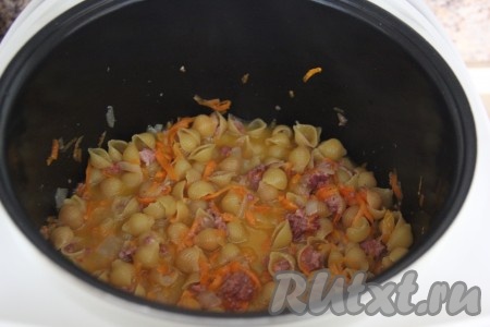 Перемешать, влить горячую воду, закрыть крышку мультиварки, выставить режим "Тушение" на 15 минут.