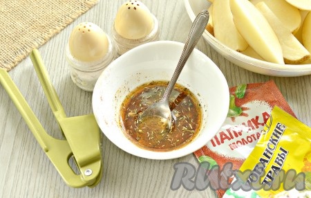 В небольшой ёмкости соединяем растительное масло с измельчённым чесноком, сушёной зеленью, солью, паприкой и молотым чёрным перцем, перемешиваем.