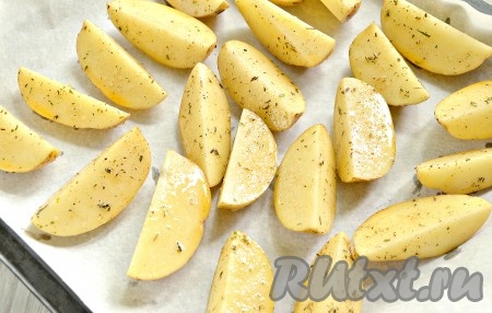 Картофельные дольки выкладываем на противень, застеленный пергаментом.