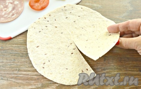 Определяем у тортильи центр и делаем до него ножницами (или ножом) разрез, как на фото. Тортилью визуально делим на 4 части (4 сектора).