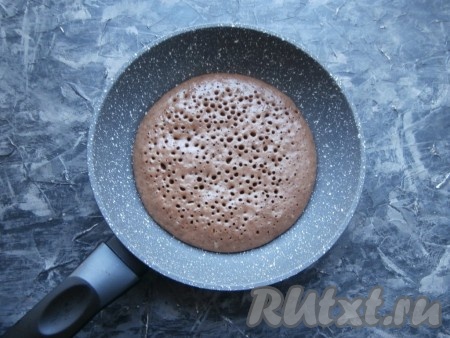 Сковороду накрыть крышкой и готовить корж на самом минимальном огне около 3 минут. Верх должен стать сухим и пузырчатым.