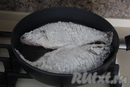 Затем влить масло в сковороду так, чтобы масло закрыло дно сковороды. Разогреть масло на огне выше среднего. Выложить лещей на сковороду с разогретым маслом.