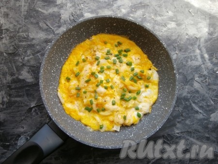 Яичницу посыпать измельчённым зелёным луком.