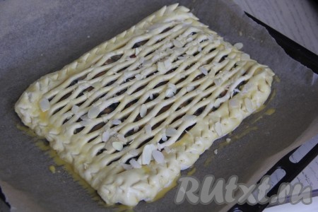 Смазать верх пирога взбитым желтком и присыпать, по желанию, лепестками миндаля.