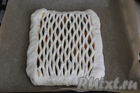 Выложить второй, фигурно нарезанный, пласт теста поверх пласта теста с начинкой и хорошо закрепить края.