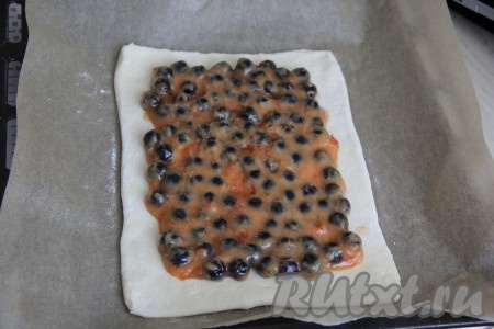 Выложить ягодную начинку по центру раскатанного пласта теста, оставляя, примерно, по 1 см теста по краям чистым (как на фото).