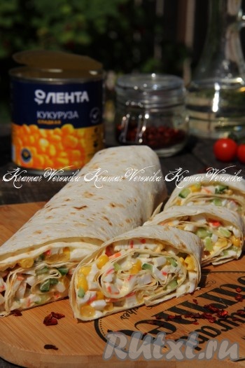 По прошествии времени развернуть, нарезать на кусочки и подать вкусный, нежный, аппетитный, сочный рулет из лаваша с начинкой из крабовых палочек, огурца и кукурузы к столу.