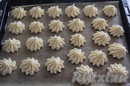 Из кулинарного мешка отсадить заварное тесто на противень, застеленный пергаментом. Если нет кулинарного мешка, можно выложить тесто с помощью ложки. Выкладывайте тесто на некотором расстоянии друг от друга.