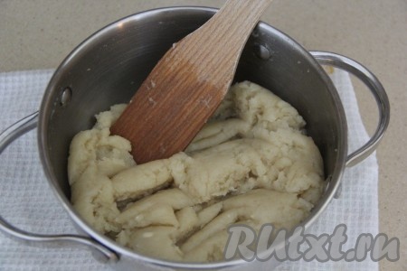 Заварить муку, интенсивно перемешивая тесто лопаткой. Заварное тесто должно стать эластичным и упругим, убрать кастрюлю с огня.