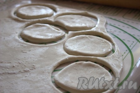 Рабочую поверхность припылить мукой, раскатать тесто в тонкий пласт. Вырезать круги диаметром 8-10 сантиметров. Вырезать кружки можно с помощью чашки соответствующего размера.