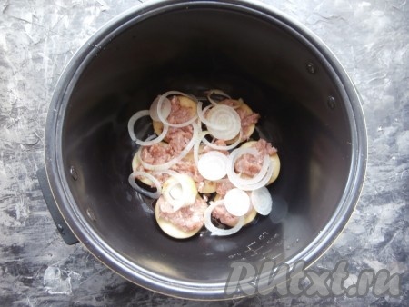 Луковицы нарезать кольцами. Поверх баклажанов распределить часть фарша и часть колец репчатого лука.