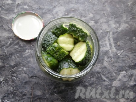 Огурцы предварительно замочить на пару часов в холодной воде, затем помыть их и нарезать кружками толщиной около 1-2 см. Наполнить банку огурцами.