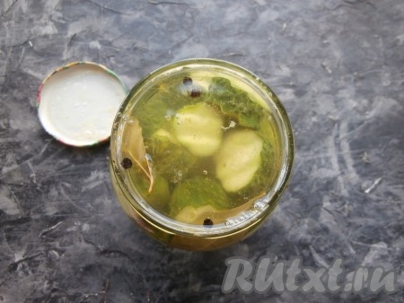 В кастрюлю с закипевшей жидкостью влить уксус, дать маринаду закипеть и залить им огурцы в банке.