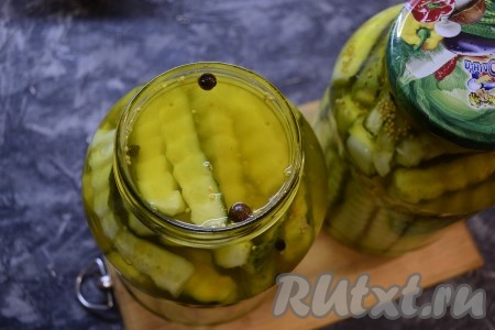 Как только маринад снова закипит, залить им до самого верха банки с огурцами.