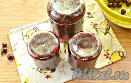 Закручиваем (или закатываем) банки с вишней крышками, переворачиваем и укутываем тёплым пледом (или одеялом), а после остывания переносим их для хранения в кладовку. Такая заготовка может отлично храниться в условиях городской квартиры.

