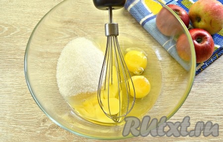 Тесто для шарлотки замешивается очень просто и достаточно быстро, поэтому сразу включаем духовку, выставляем температуру 180 градусов. Приступаем к замешиванию теста, для этого в миску разбиваем куриные яйца, подсыпаем к ним сахар.