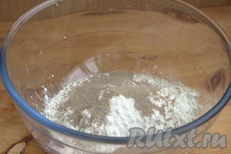 Добавить сахар, соль, дрожжи и хорошо перемешать с мукой.