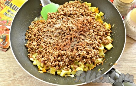 В сковороду с обжаренными овощами добавляем подготовленную гречневую крупу, солим по вкусу и сдабриваем молотыми специями (я использовала чёрный молотый перец и паприку).