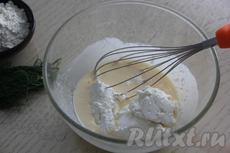 Перемешать смесь яйца и кефира венчиком до однородности, затем выложить творог и снова перемешать венчиком.