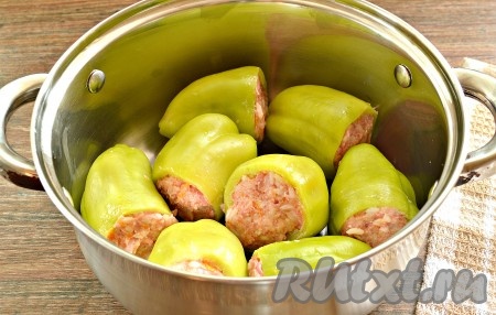 Наполняем перцы подготовленной мясной начинкой. Сразу выкладываем их в широкую кастрюлю (или сковороду с высокими бортами).