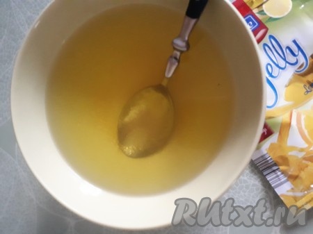 Покупное желе из пакетика пересыпать в глубокую тарелку, залить 350 мл горячей кипячёной воды, тщательно перемешать и отставить в сторону. У меня лимонное желе, но можно взять любое по своему вкусу и желанию.